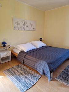a bedroom with a bed with a blue blanket and white pillows at Apartments Velic in Crikvenica