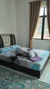 a bed in a room with a window at MAA HOMESTAY BATU BURUK in Kuala Terengganu +9 photos