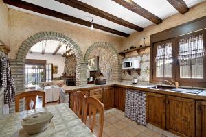 a kitchen with wooden cabinets and a table with chairs at Casa Montepinar in Chiclana de la Frontera