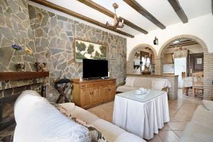 a living room with a tv on a stone wall at Casa Montepinar in Chiclana de la Frontera