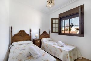 a bedroom with two beds and a window at Casa Montepinar in Chiclana de la Frontera +30 photos