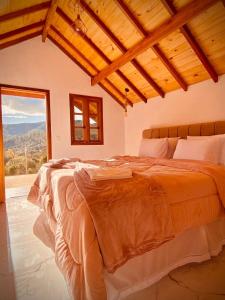 a bedroom with a large bed with a large window at Pousada Solard'isabell in Monte Verde