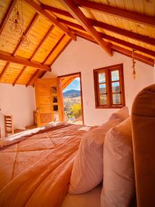 a large bed in a room with a large window at Pousada Solard'isabell in Monte Verde