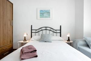 een slaapkamer met een groot wit bed met 2 lampen bij Casa Colomera 1 in Barbate