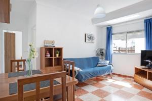 een woonkamer met een blauwe bank en een tafel bij Casa Colomera 1 in Barbate
