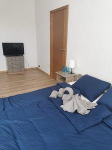 Un dormitorio con una cama azul con toallas. en Telegrafs, en Ventspils