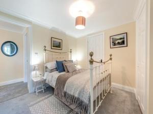 a bedroom with a bed and a lamp and a table at The Stable, Cuffern Manor Cottages in Haverfordwest