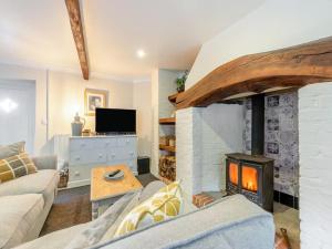 a living room with a fireplace and a couch at The Stable, Cuffern Manor Cottages in Haverfordwest