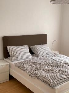 a bed with a black and white comforter and two pillows at Ferienwohnung FM Moselle in Reil