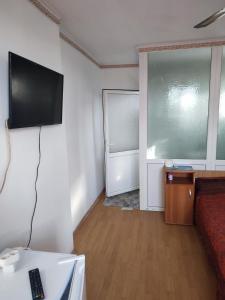 a living room with a flat screen tv on the wall at Hostel EMY Camere cu baie proprie aproape de plaja 3 Papuci in Constanţa