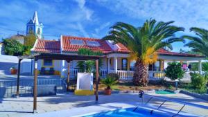 una casa con una palmera y una piscina en 6 Persoons Vakantiewoning Portugal - Casa do Balão - en - Casa Pequeno Pintor en Figueira e Barros