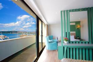 a room with a balcony with a view of the water at Çanakkale Bosphorus Port Aspen Hotel in Çanakkale