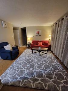 uma sala de estar com um sofá vermelho e um tapete em Cozy apt in center of Saint John NB em Saint John