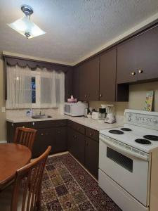 a kitchen with a white stove and a table at Cozy apt in center of Saint John NB in Saint John