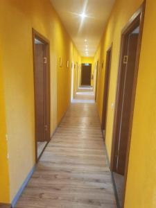 un pasillo vacío con paredes amarillas y suelo de madera en Telegrafs, en Ventspils