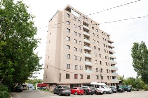 a tall building with cars parked in a parking lot at Altheda Living Zamca C4 in Suceava