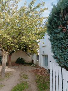 a white house with a white fence and trees at Appartement dans maison atypique in Montrond-les-Bains