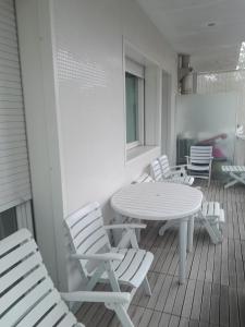 une terrasse couverte avec une table blanche et des chaises. dans l'établissement Casa Roberto, à Riccione