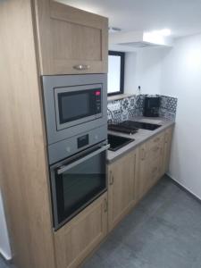 a kitchen with a stove and a microwave at Appartement dans maison atypique in Montrond-les-Bains