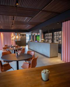 un ristorante con tavoli e sedie e un bar di Struer Grand Hotel a Struer Altre 37 foto