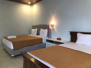 Batukliang的住宿－Bello Bungalow，酒店客房配有两张床和一张书桌