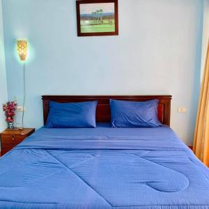 1 dormitorio con cama azul y almohadas azules en Bird Bungalow Koh Phangan, en Haad Rin