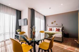a bedroom with a bed and a glass table and chairs at Spinola Stays in St. Julianʼs
