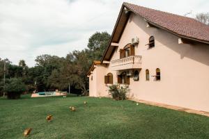 une maison avec une cour avec des poulets sur l'herbe dans l'établissement Wine Residence, à Garibaldi