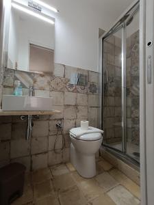 a bathroom with a toilet and a sink and a shower at casa ANNA in Trapani