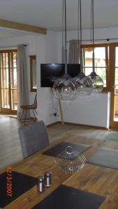 a living room with a table and a chandelier at Ferienlodge Karwendelblick in Krün