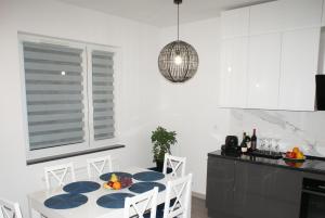 a kitchen with a table and chairs in a room at Apartament Termalny na Długiej 6 in Uniejow
