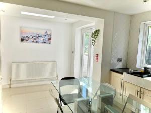 a dining room with a glass table in a kitchen at Canary Wharf Holiday Rooms in London