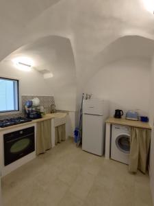 Il comprend une cuisine équipée d'une cuisinière et d'un lave-linge/sèche-linge. dans l'établissement La Mia Corte, à Tuglie