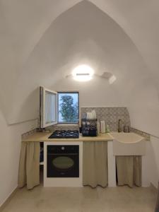 - une cuisine avec un comptoir, une cuisinière et un évier dans l'établissement La Mia Corte, à Tuglie
