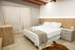 um quarto com uma grande cama branca e uma janela em Wine Residence em Garibaldi