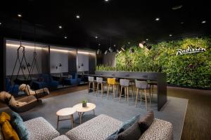 a lobby with a bar with a plant wall at Radisson Hotel & Suites Zurich in Opfikon