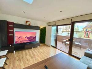 a living room with a large flat screen tv at Atico triplex en pleno Triana in Seville