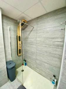 uma casa de banho com uma cabina de duche em vidro e uma lata de lixo em Atico triplex en pleno Triana em Sevilha