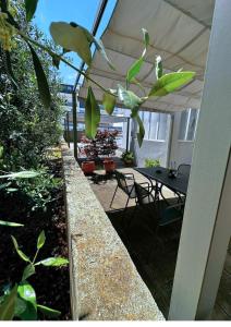 eine Terrasse mit einem Tisch und Stühlen unter einem Sonnenschirm in der Unterkunft The Martinez Holiday House - Zadar in Zadar