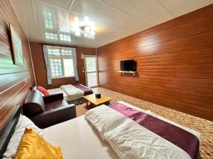 a bedroom with a bed and a couch and a tv at Taroko Little Fish in Xincheng