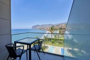 balcón con mesa, sillas y vistas al océano en Golden Residence Hotel en Funchal