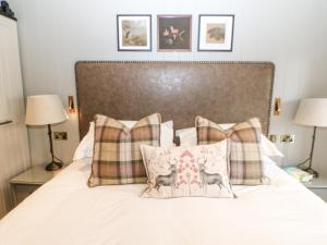a bedroom with a bed with two pillows and two lamps at Brampton in Appleby