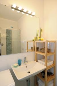 baño con lavabo y espejo grande en Amalfia Apartments, en Amalfi