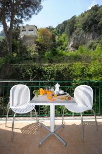 2 sillas y una mesa con una bandeja de fruta en Amalfia Apartments, en Amalfi