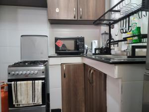 een keuken met een fornuis en een magnetron bij Cool Apartment Near all Embassies in Ruaka