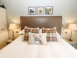 a white bed with two pillows and two lamps at Marton in Appleby