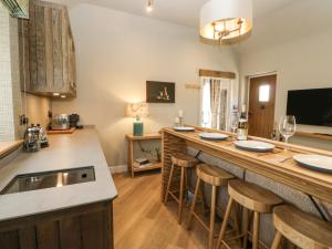 アップルビーにあるMurton Cottageのカウンターとスツール付きのバーのあるキッチン