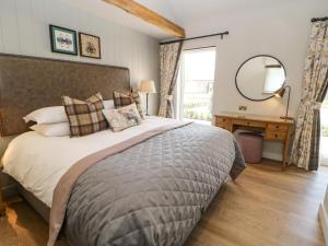 アップルビーにあるMurton Cottageの大きなベッドと鏡のある寝室