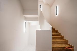 a staircase in a house with white walls and wooden floors at Spinola Stays in St. Julianʼs