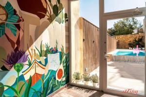 una puerta abierta a una piscina con un mural colorido en Spinola Stays, en San Julián